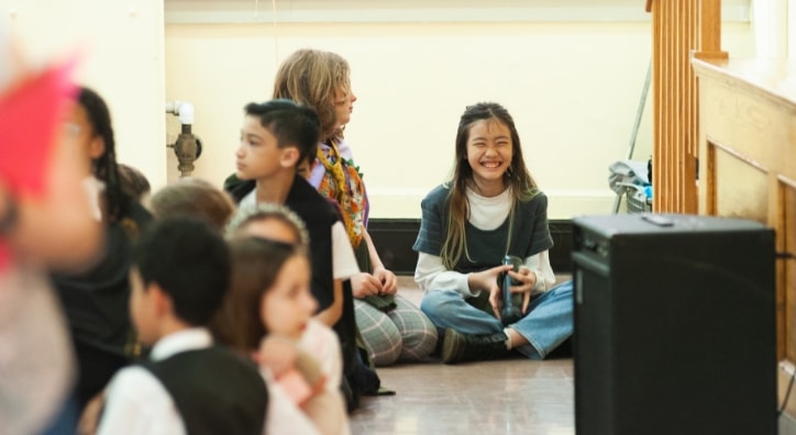 A student sitting cross legged laughing