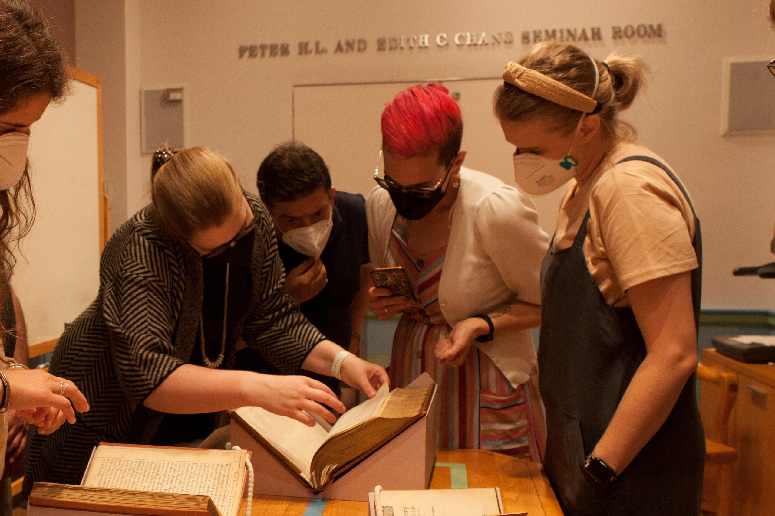 A group of teachers examining a copy of the First Folio of Shakespeare's works at Columbia's Rare Book Room, guided by Shakespeare scholar Mario DiGangi.